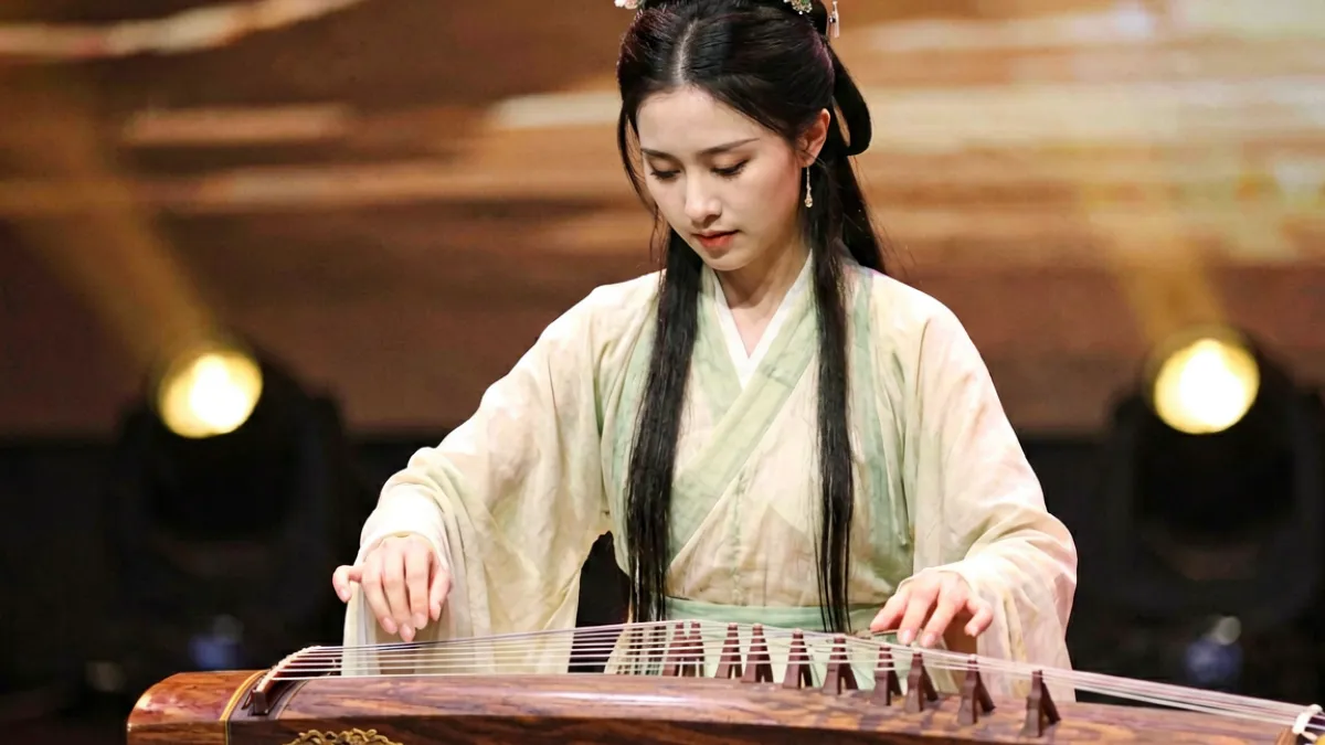 伊人直播才艺主播珊珊在舞台灯光下表演古筝演奏的直播截图